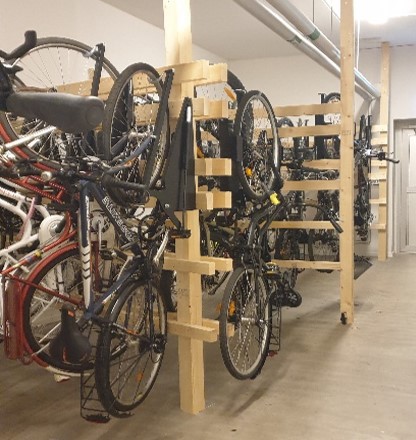 Cyklar som förvaras hängande i cykelställ i ett rum