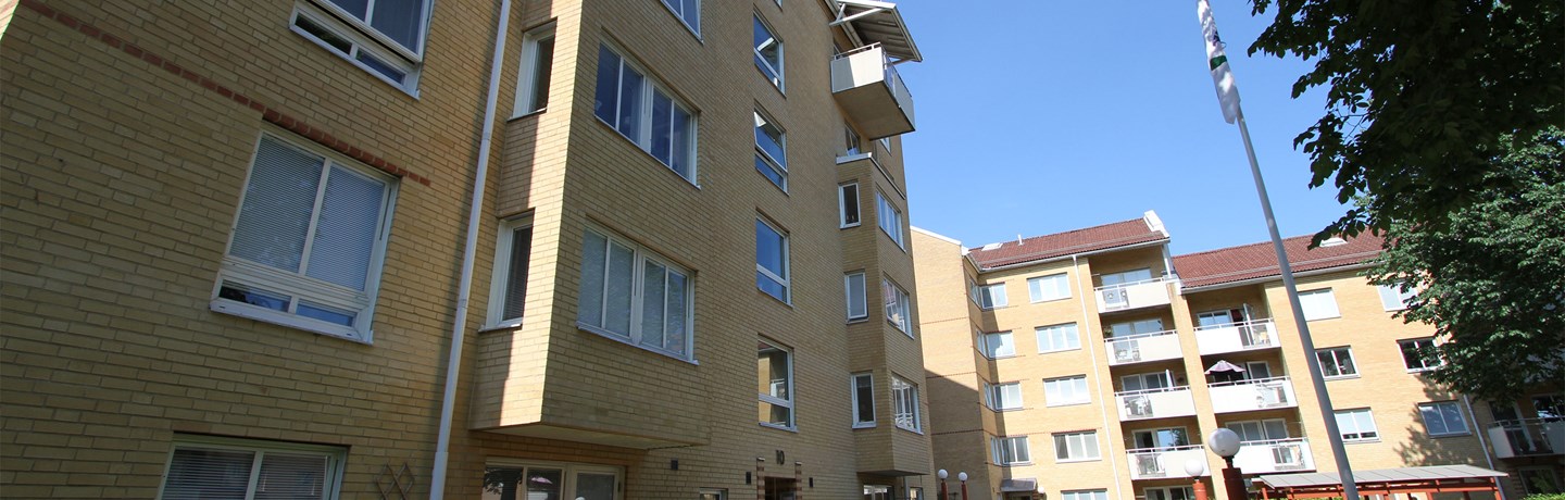 Tegelfasad på 5 våningshus med balkong mot innergård