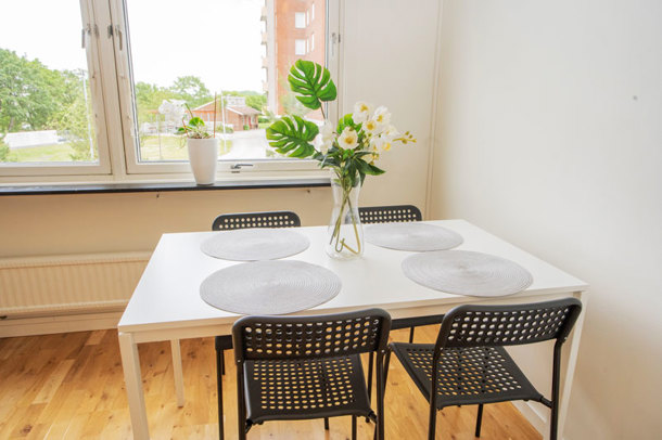 A private kitchen with a white table and four black chairs