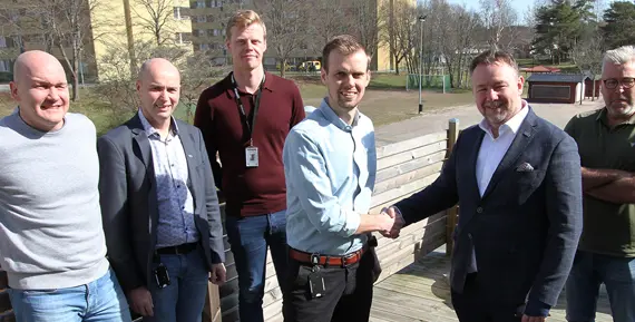 Ett handslag mellan Sernekes arbetschef Christoffer Sundin och Eidars vd Urban Blom, framför kvarteret Guldvingen