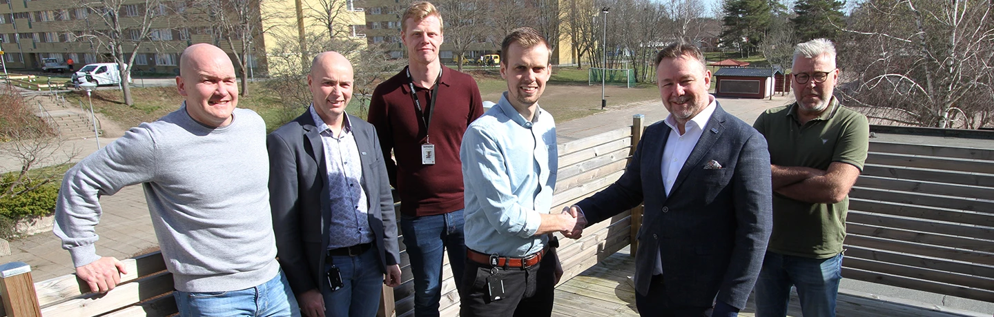 Ett handslag mellan Sernekes arbetschef Christoffer Sundin och Eidars vd Urban Blom, framför kvarteret Guldvingen