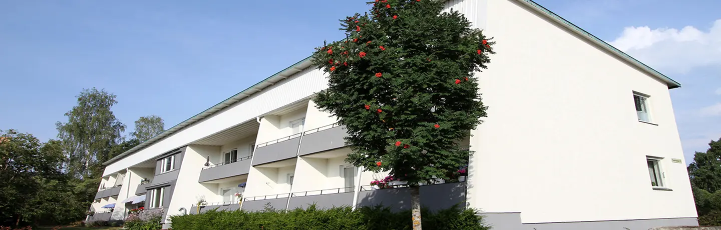 Vitt tvåvåningshus med gråa balkonger