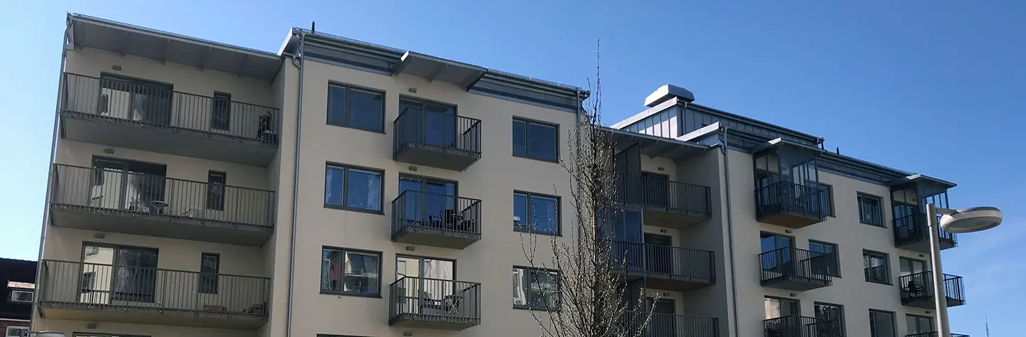 Ett av de lägre husen i kvarteret Mars i Trollhättan centrum tecknar sig mot blå himmel i bakgrund.