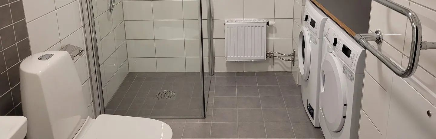 Ett modernt badrum med vitt kakel