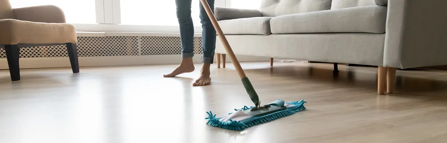 Person som moppar ljusa parkettgolv