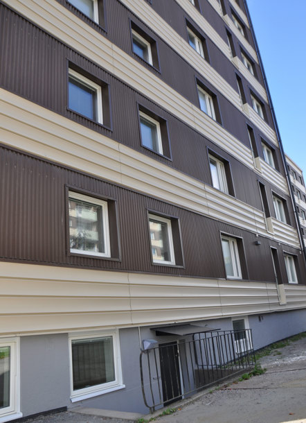 Brungult höghus med en källartrappa