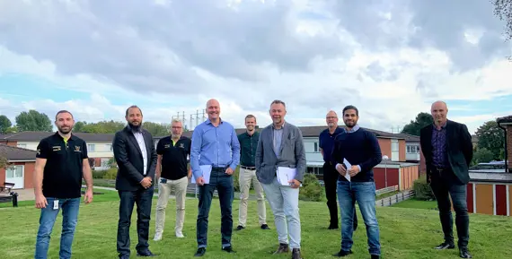 De närvarande vid kontraktsskrivningen framför låghusen i kvarteret Guldvingen.
