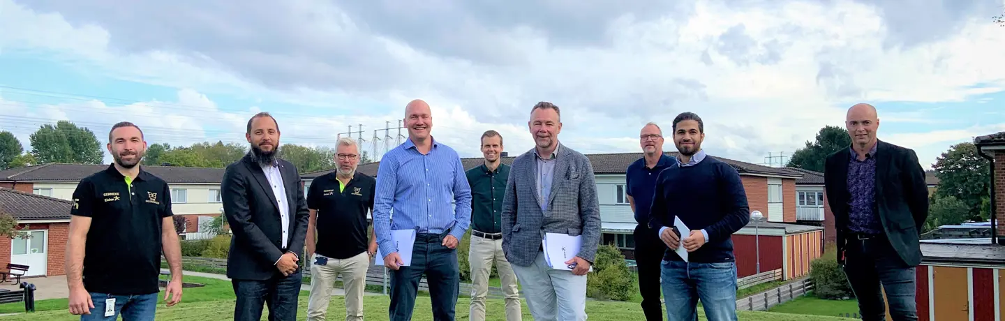 De närvarande vid kontraktsskrivningen framför låghusen i kvarteret Guldvingen.