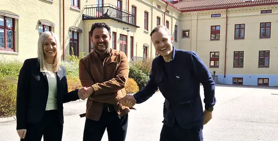 Josefine Nordström, avdelningschef Lokal och Daniel Ruus, Fastighetsutvecklingschef på Eidar skakar hand med Arvin Yarollahi, VD och verksamhetschef för Specialistläkarna. Stavregården i bakgrunden ska byggas om till center för specialistvård.