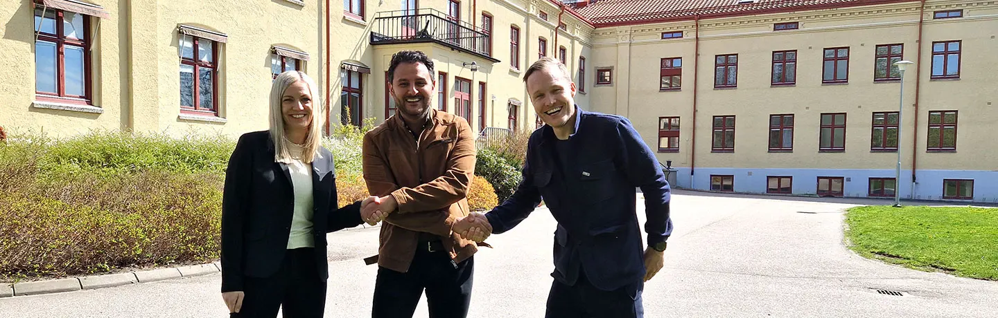 Josefine Nordström, avdelningschef Lokal och Daniel Ruus, Fastighetsutvecklingschef på Eidar skakar hand med Arvin Yarollahi, VD och verksamhetschef för Specialistläkarna. Stavregården i bakgrunden ska byggas om till center för specialistvård.