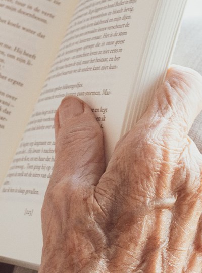 Äldre kvinna som läser en bok
