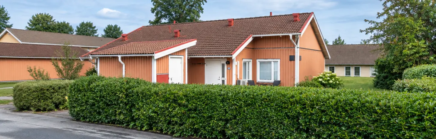 Enplans parhus i Åsaka med uteplats med omgivande häck och med ett förråd vid sidan om. 